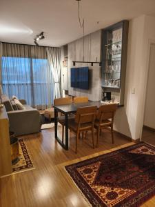 a living room with a table and chairs and a couch at Premium Apartment in Bagé in Bagé