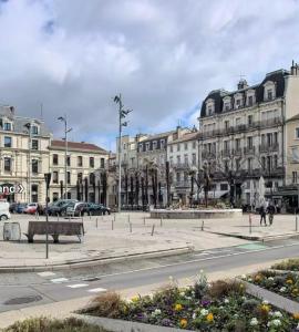 a city square with buildings and a street with benches at Le Grand Briand - Champ de Mars in Valence