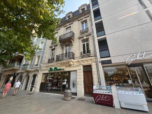a building on a city street with a store at Le Grand Briand - Champ de Mars in Valence