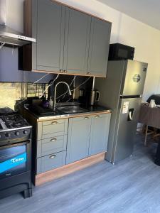a kitchen with a stove and a refrigerator at MiRe- Alojamiento con jacuzzi in Maldonado