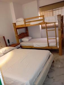 a room with two bunk beds in a room at Hotel Santa Ana in Baranoa