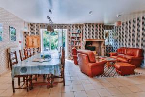 a living room with a table and chairs and a fireplace at Moulin de Vézelay - Maison d'hôtes in Fontenay-près-Vézelay