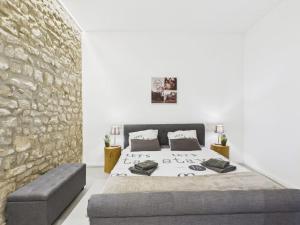 a bedroom with a large bed and a stone wall at Sam's Cottage Suite in Niederweis
