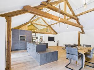 a kitchen and living room with wooden beams at Sam's Cottage Suite in Niederweis +18 photos