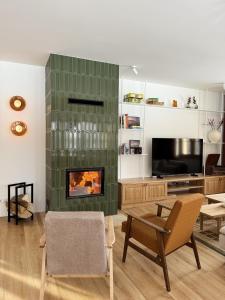 a living room with a fireplace and a tv at Sielski Dom in Suwałki