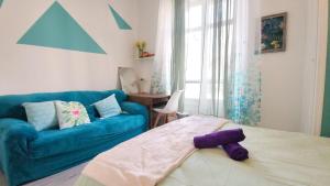 a living room with a blue couch and a bed at Cosy Jade - Quartier Vivant du Chateau - Parking souterrain in Pau