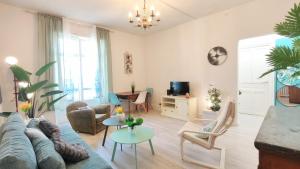a living room with a couch and a table at Cosy Jade - Quartier Vivant du Chateau - Parking souterrain in Pau