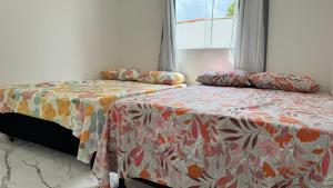 a bedroom with two beds and a window at Bela casa jacumã in Conde +16 photos