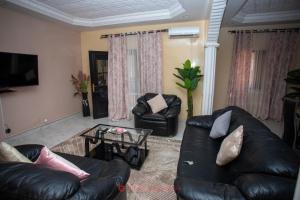 a living room with a leather couch and a table at Cabral residence in Guediawaye