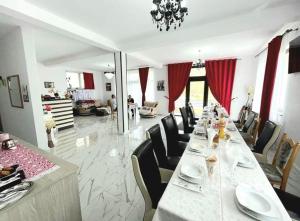 a long long table with chairs and a dining room at Vila CASA HATERE in Moisei
