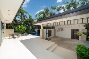 an exterior view of a house with a patio at Coconut villa Phuket Free Airoport Pick up from 7 days in Laguna Phuket
