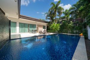 a swimming pool in the backyard of a house at Coconut villa Phuket Free Airoport Pick up from 7 days in Laguna Phuket