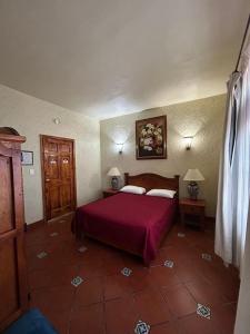a bedroom with a bed with a red bedspread at HOTEL COLONIAL MATAMOROS in Matamoros