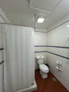 a bathroom with a toilet and a shower curtain at HOTEL COLONIAL MATAMOROS in Matamoros +24 photos