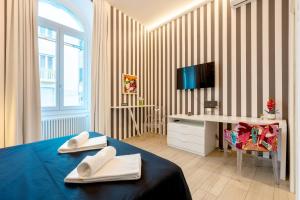 a bedroom with a bed and a desk and a television at InLuce Terrazza in Sanremo
