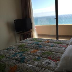 a bedroom with a bed and a flat screen tv at Arenamaris Apartment in Algarrobo
