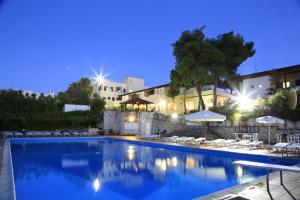 a pool with chairs and umbrellas in front of a building at Hotel Club Bellavista in Vieste +12 photos