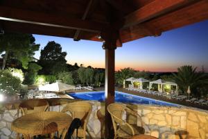 a patio with a table and chairs and a pool at Hotel Club Bellavista in Vieste