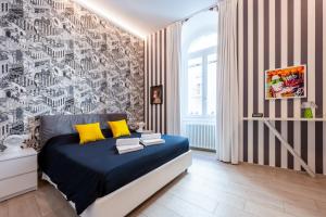 a bedroom with a blue bed with yellow pillows at InLuce Terrazza in Sanremo