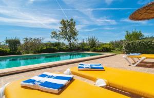 a pool with two yellow lounge chairs and an umbrella at Ca Na Neus Pollenca in Pollença