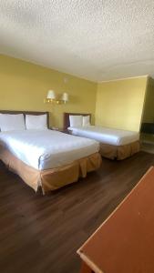 two beds in a hotel room with two at Evergreen Plaza Inn in Metairie