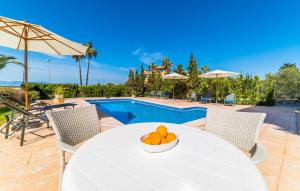 a table with a bowl of oranges on it next to a pool at Redrema in Llucmajor