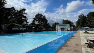 a large swimming pool with blue water at The Cosy Retreat in Droitwich