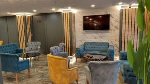 a waiting room with blue chairs and a tv at QUEEN PALACE HOTEL TRABZON in Trabzon
