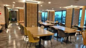 a restaurant with wooden tables and chairs and windows at QUEEN PALACE HOTEL TRABZON in Trabzon