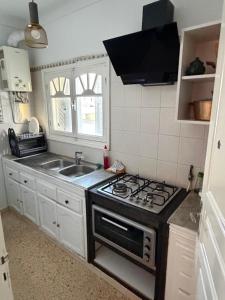 a kitchen with a stove and a sink at home zeinbe 2 in Hammamet