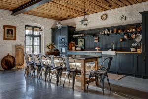 a kitchen with blue cabinets and a wooden table and chairs at Darmyšl No13 in Staré Sedlo