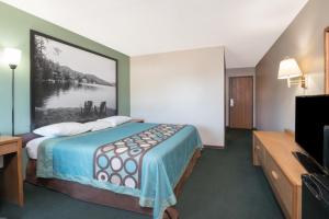 a hotel room with a bed and a painting on the wall at Super 8 by Wyndham Milbank SD in Milbank +14 photos