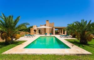 a swimming pool in front of a house at Clovetes in Son Servera