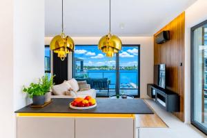 a kitchen and living room with a view of the ocean at Marina Ostróda - 80 metrów luksusu z widokiem na jezioro in Ostróda