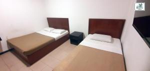 a small room with two beds and a table at Bayu Inn in Kota Kinabalu