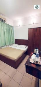 a small room with a bed and a table at Bayu Inn in Kota Kinabalu