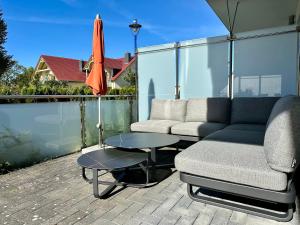 a patio with a couch and a table and an umbrella at Haus Sonne in Thiessow