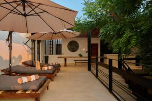 a patio with chairs and umbrellas and a table at Hotel Compartir in Brisas de Zicatela