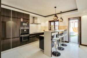 a kitchen with stainless steel appliances and black cabinets at Beach Villa with Jacuzzi & Garage by HostWise in Vila Chã