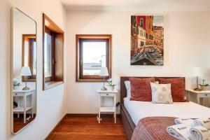 a bedroom with a bed and two windows at Beach Villa with Jacuzzi & Garage by HostWise in Vila Chã