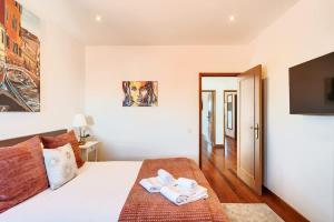 a bedroom with a bed with two towels on it at Beach Villa with Jacuzzi & Garage by HostWise in Vila Chã