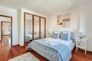 a bedroom with a large bed with blue pillows at Beach Villa with Jacuzzi & Garage by HostWise in Vila Chã +55 photos