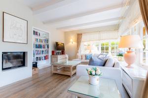 a living room with a white couch and a tv at Ferienhaus Cäcilienhof West in Kampen