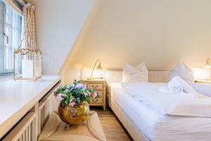 a bedroom with two beds and a vase with flowers at Ferienhaus Cäcilienhof West in Kampen