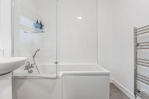 a white bathroom with a shower and a sink at Zuri Luxe Escape - Wolverhampton in Bilston +32 photos