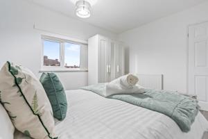 a white bedroom with a bed with pillows at Zuri Luxe Escape - Wolverhampton in Bilston