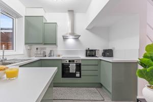 a kitchen with green cabinets and a white counter top at Zuri Luxe Escape - Wolverhampton in Bilston