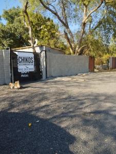 a cat laying in a parking lot next to a fence at affordable room rustenburg in Kroondal