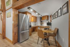 a kitchen with a table and a stainless steel refrigerator at auxportesdesMilleIles in Laval