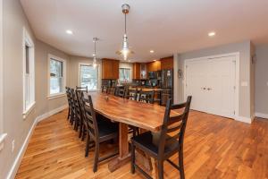 a kitchen and dining room with a wooden table and chairs at Wake Up Grateful by Railey Vacations in Swanton